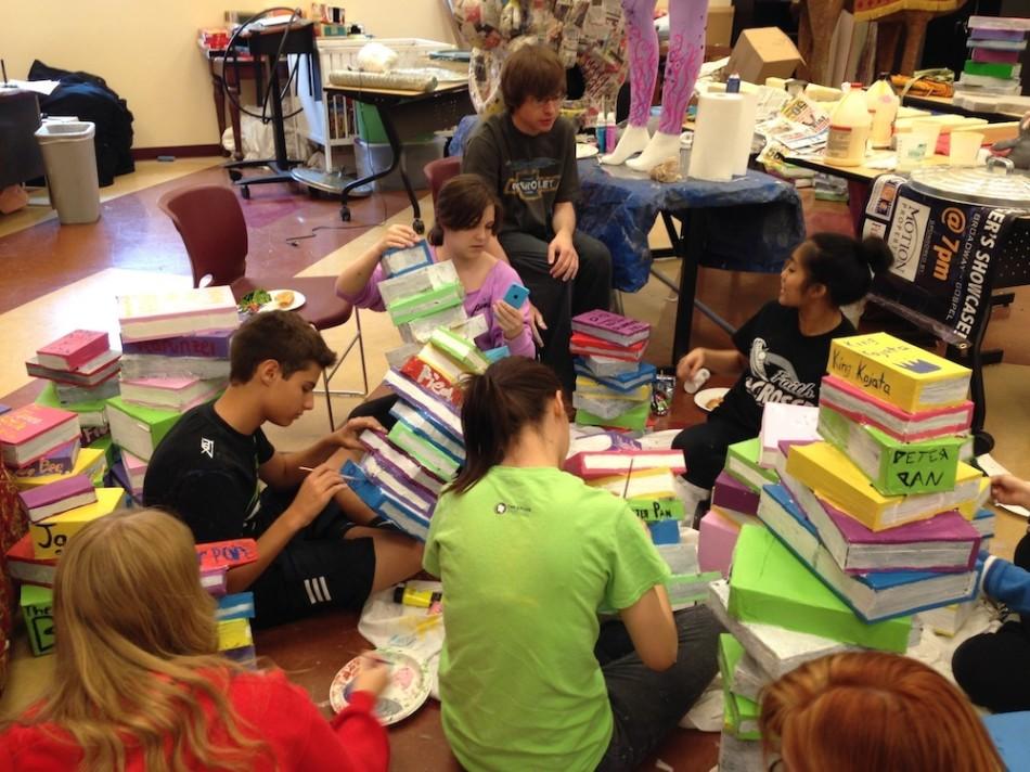 Cast and crew paint set storybook props for this weekend performance.