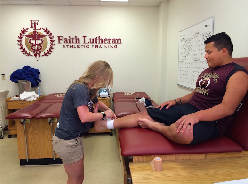 Photo caption: New trainer wraps Josh Rodriguezs ankle after an injury