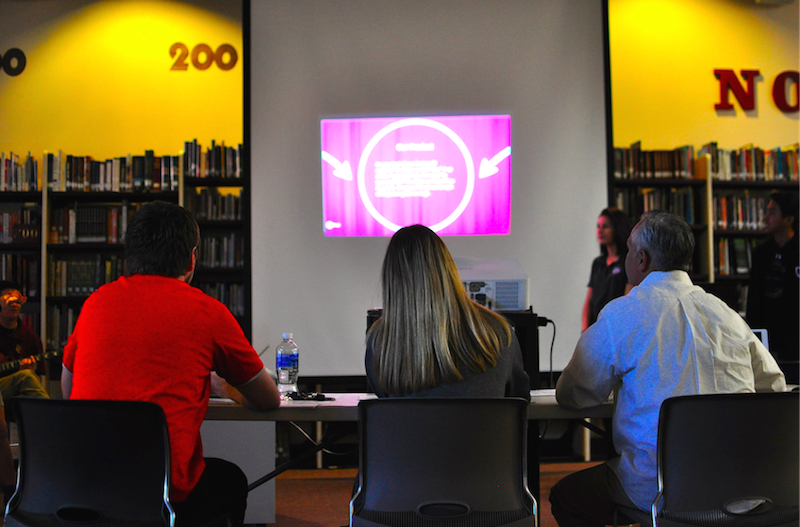 The 3 sharks of the shark tank judging students giving a presentation.