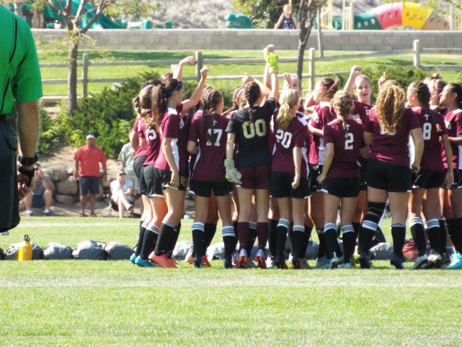 Photo caption: The women huddle for a victory.