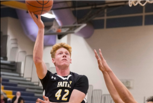 Elijah Kothe shoots a basket to boost the Crusaders score