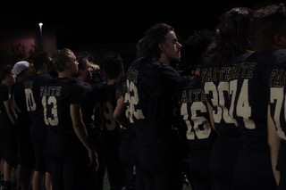 Several players on the sideline look on as their team would not score a point throughout the game.