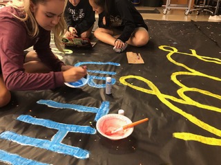 Student council member Saige Schweitzer decorates for the pep rally.  