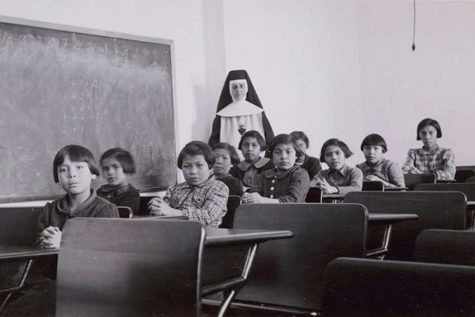 A nun and group of Indigenous students at a Residential School in Manitoba, Canada in 1940.
