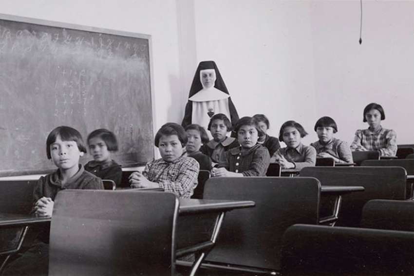 A+nun+and+group+of+Indigenous+students+at+a+Residential+School+in+Manitoba%2C+Canada+in+1940.