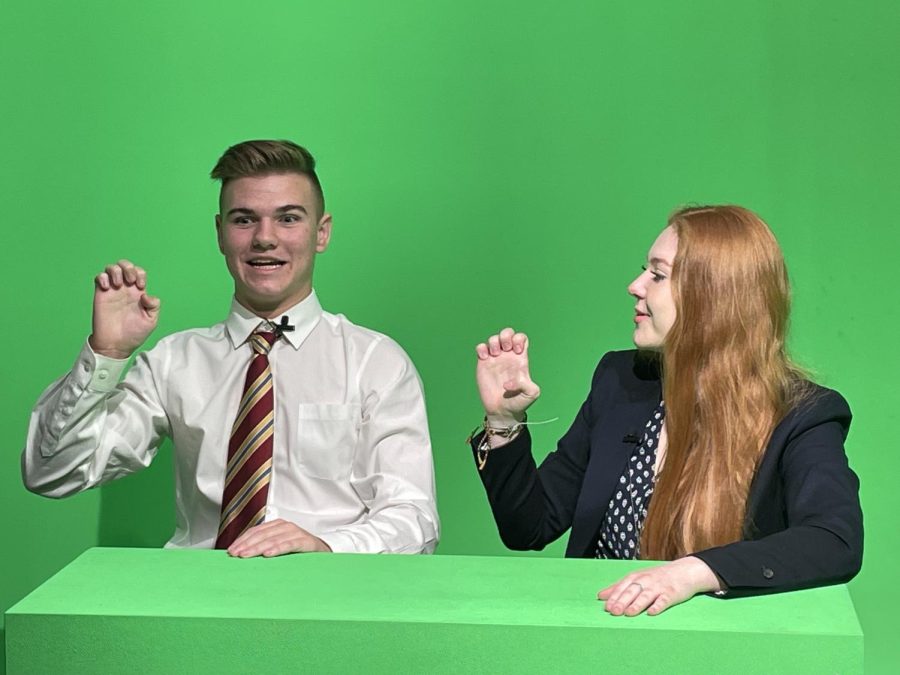 Addisen Binderim teaches Caden Merrill a little sign language for the broadcast. 