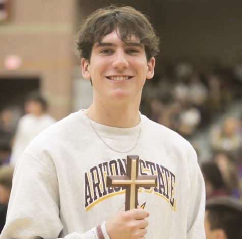 Closing chapel, Donavyn holds the special cross given to all seniors as they leave Faith Lutheran.